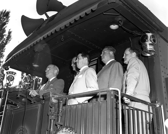 President Harry S. Truman (left) speaks from the rear platform of a train during his trip to the West Coast, 1948, United States Navy, Harry S. Truman Library & Museum