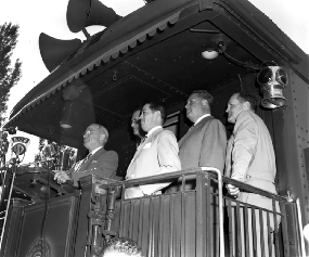 President Harry S. Truman (left) speaks from the rear platform of a train during his trip to the West Coast, 1948, United States Navy, Harry S. Truman Library & Museum